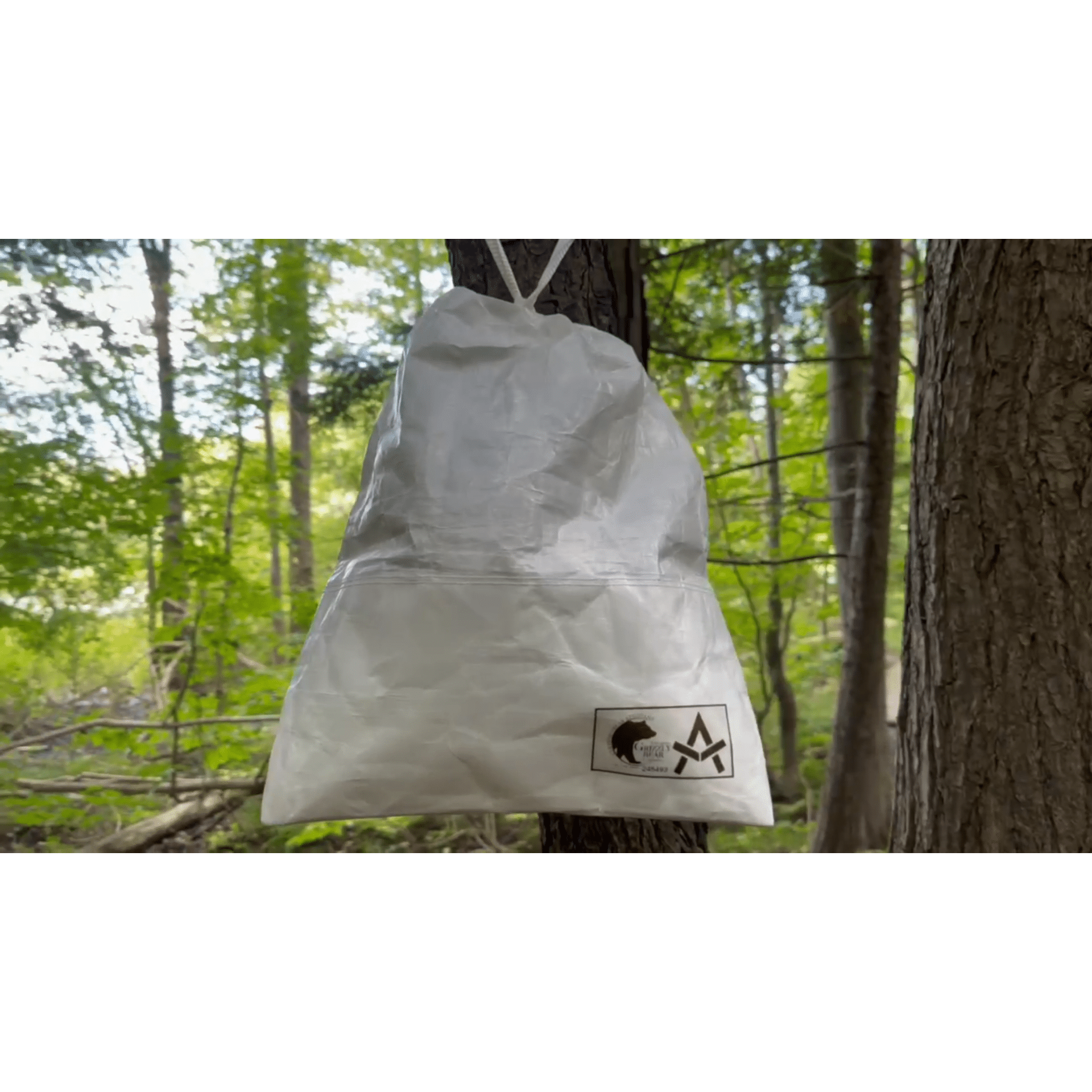 Ultralight Bear Locker: Grizzly Bear Resistant Bag Adotec Gear White Waterproof Dry Bag Hanging from Tree in Lush Forest Setting